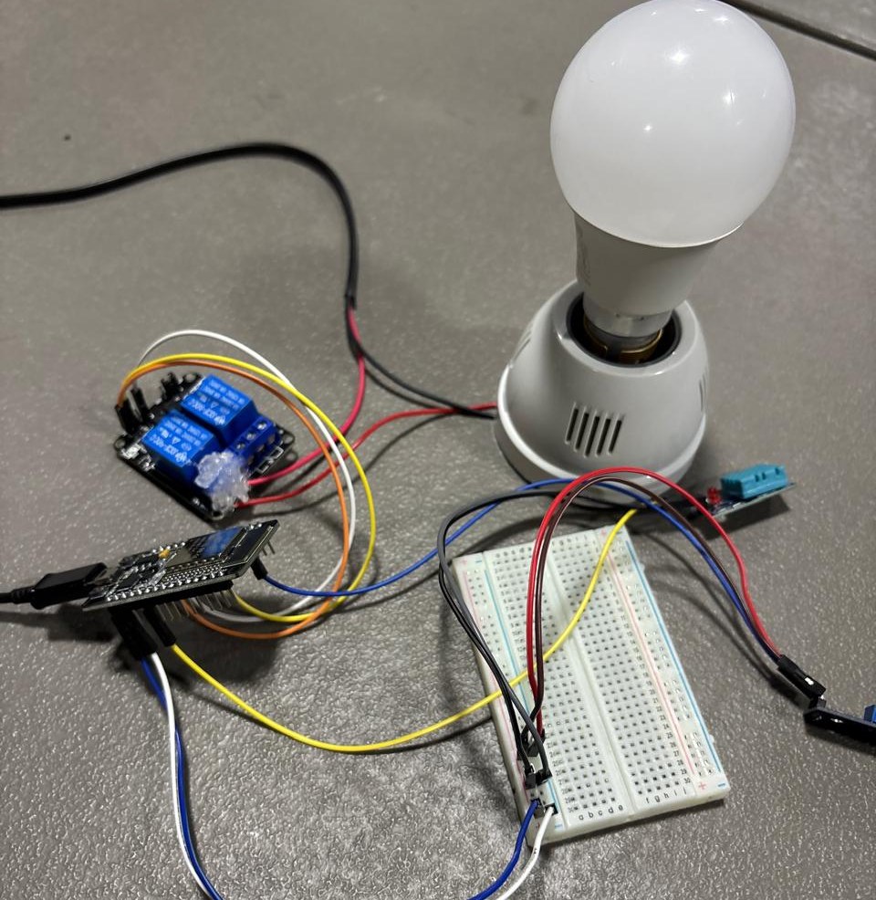 The full rig: ESP32, DHT11 and LDR divider on the breadboard, relay and bulb